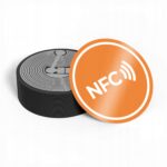 Pomarańczowa naklejka NFC antymetal NTAG215 z białym napisem 25 mm