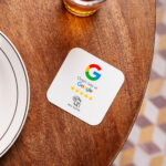 Naklejka NFC Google Opinie 12 × 12 cm na stoliku w restauracji